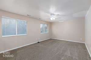 Carpeted spare room with baseboards and a ceiling fan