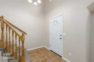 Foyer featuring stairs and light tile patterned floors