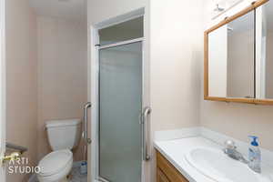 Full bathroom with vanity, a shower stall, and tile patterned flooring