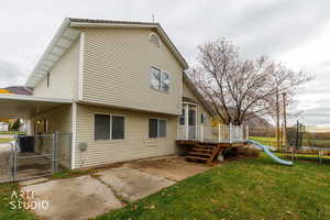 Back of house featuring a gate, a patio area, a trampoline, and a deck