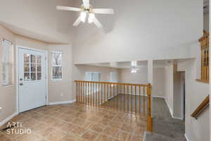 Entrance foyer with a ceiling fan, a high ceiling, and light tile patterned flooring