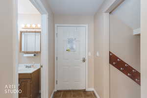 Doorway with tile patterned floors and baseboards