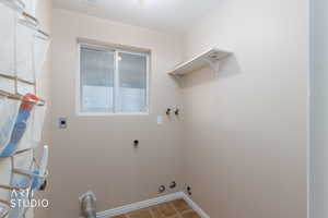Washroom with hookup for an electric dryer, washer hookup, and light tile patterned floors