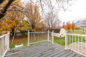 Deck featuring a storage unit, a fenced backyard, and a mountain view