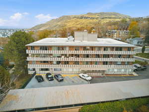 View of building exterior with a mountain view and uncovered parking