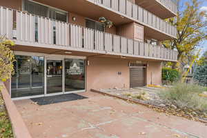 View of exterior entry with a garage and stucco siding