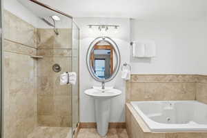 Full bathroom featuring a whirlpool tub, a shower stall, and tile patterned flooring