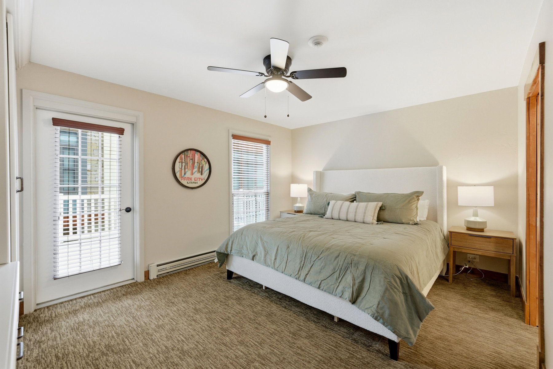 Bedroom featuring carpet flooring, ceiling fan, and a built-in transom window above the door