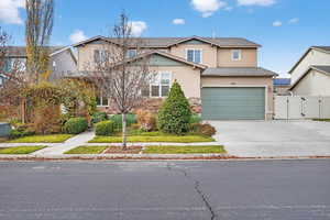 Traditional home featuring a gate, concrete driveway, stucco siding, and stone siding
