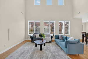 Living room with light wood-style floors and a high ceiling