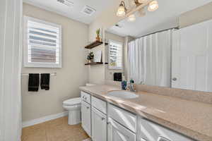 Full bathroom featuring curtained shower, vanity, and light tile patterned floors