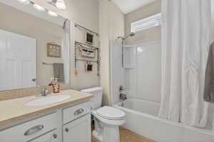 Bathroom with shower / tub combo, vanity, and light tile patterned floors