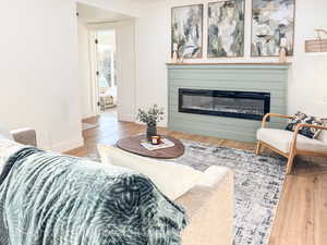 Living room featuring light wood finished floors and a glass covered fireplace