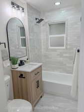 Full bathroom featuring vanity, shower / bath combination, and recessed lighting