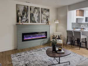 Living room featuring light wood finished floors and a glass covered fireplace