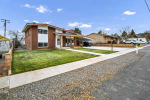 View of front of property featuring a carport, driveway, and covered porch