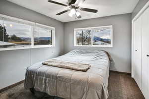 Carpeted bedroom featuring a closet and a ceiling fan