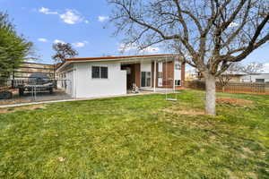 Rear view of house with a fenced backyard and a patio area