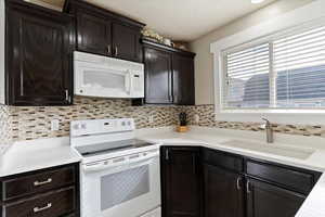 Fresh kitchen with new countertops, tile backsplash and lovely craftsman casing on windows