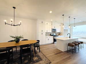 Large open kitchen featuring white flat panel cabinets with black hardware, recently upgraded to include beautiful tile backsplash, Frigidaire appliances, quartz countertops pendant lighting, and a large walk in pantry. Lots of natural light!