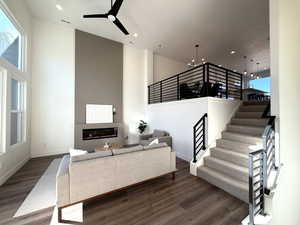 Grand living room with tall ceilings, electric fireplace, open railing.
