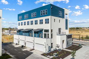 Rear view of house featuring stucco siding, driveway, and an attached garage