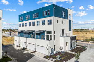 Modern multi-story building featuring white stucco and blue horizontal siding