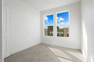 Carpeted spare room with baseboards