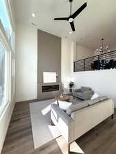 Grand living room with tall ceilings, electric fireplace, open railing.