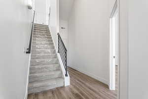 Stairs featuring wood finished floors and baseboards