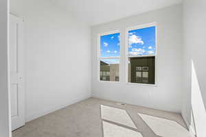 Carpeted empty room with baseboards