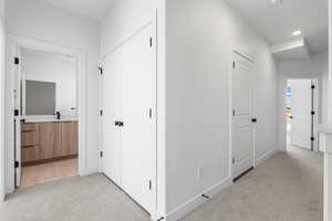 Hallway featuring light colored carpet and recessed lighting