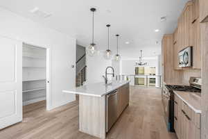 Kitchen with light brown cabinetry, appliances with stainless steel finishes, modern cabinets, a chandelier, and recessed lighting