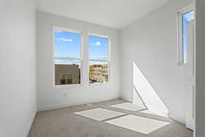 Carpeted empty room with healthy amount of natural light