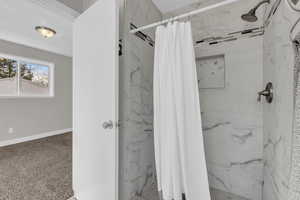 Bathroom featuring a marble finish shower and carpet floors