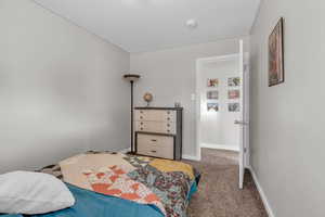 Bedroom featuring carpet and baseboards