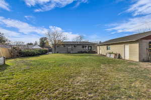 Back of house with concrete block siding and an outdoor structure