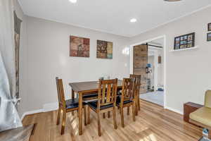 Dining space featuring a barn door, wood finished floors, and recessed lighting