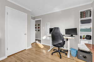 Office space featuring ornamental molding and light wood-type flooring