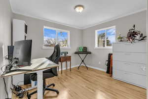 Home office featuring ornamental molding and light wood-style flooring