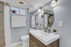 Full bath with vanity, a shower with curtain, and a textured wall