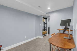 Office with light colored carpet and recessed lighting