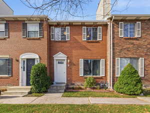 Colonial home featuring brick siding and a chimney