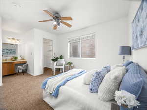 Bedroom with carpet, built in study area, a ceiling fan, and a spacious closet
