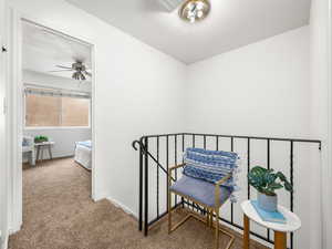 Hall featuring carpet floors and an upstairs landing