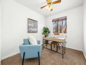 Carpeted home office with baseboards and a ceiling fan