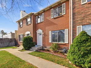 Colonial home featuring brick siding and a chimney