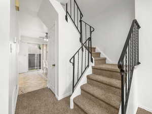 Stairs with carpet and a ceiling fan