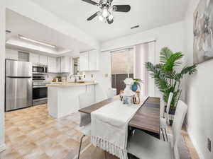 Dining space with a ceiling fan and a tray ceiling