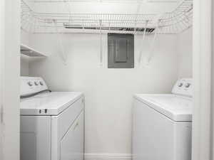 Laundry area featuring electric panel and separate washer and dryer